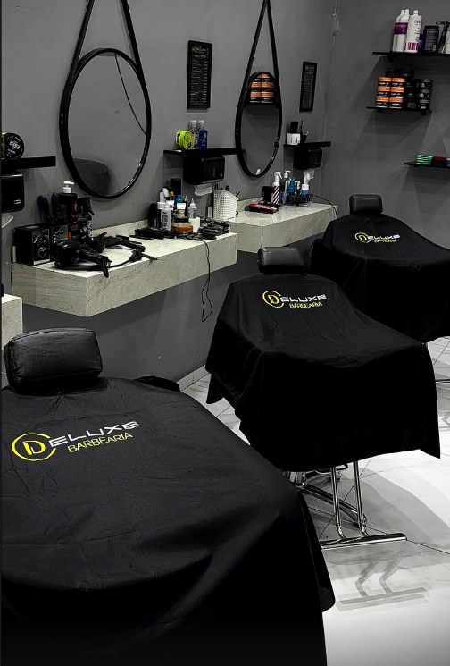 Capas de corte reais da Deluxe nas cadeiras da barbearia
