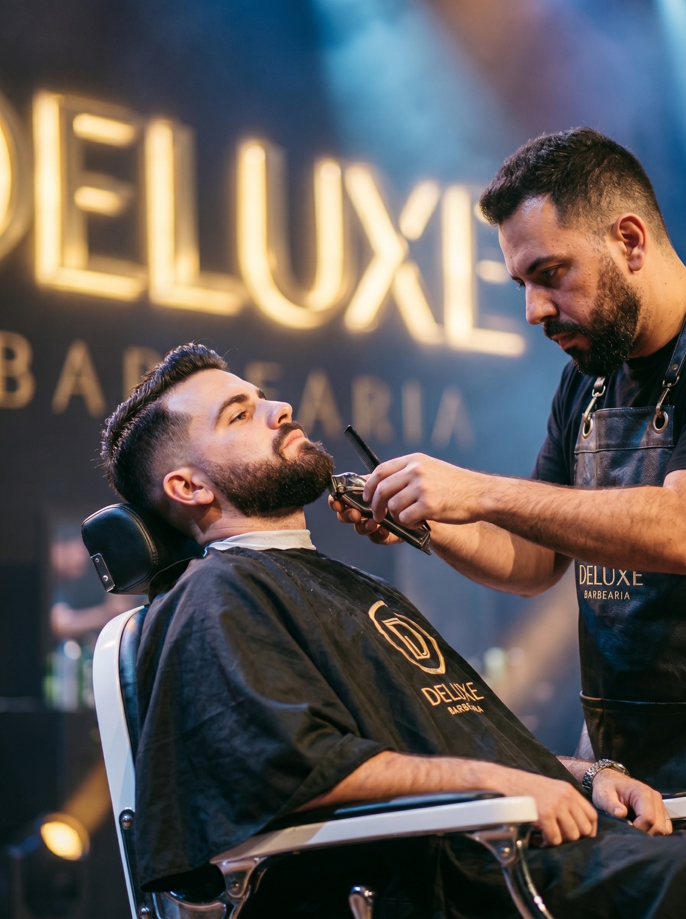 Atendimento de barba ao cliente na cadeira da Deluxe